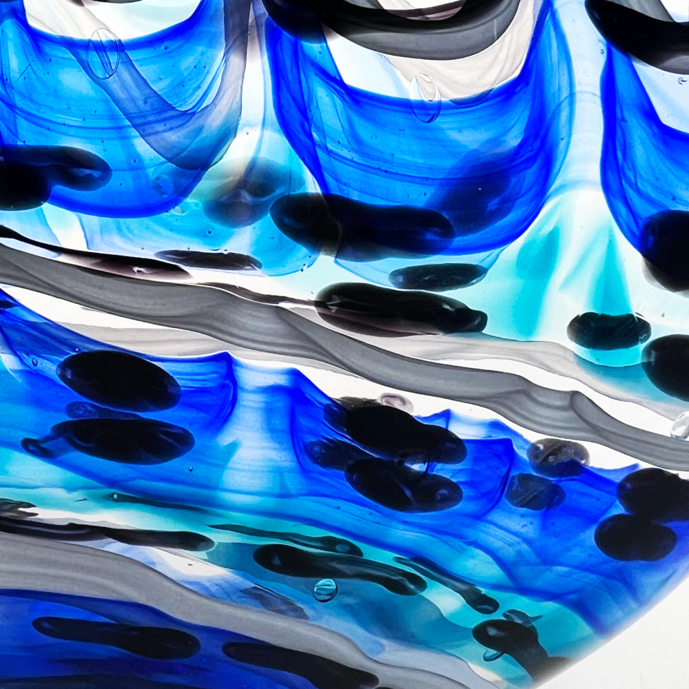 Close-up of blue, black, and white abstract glass art