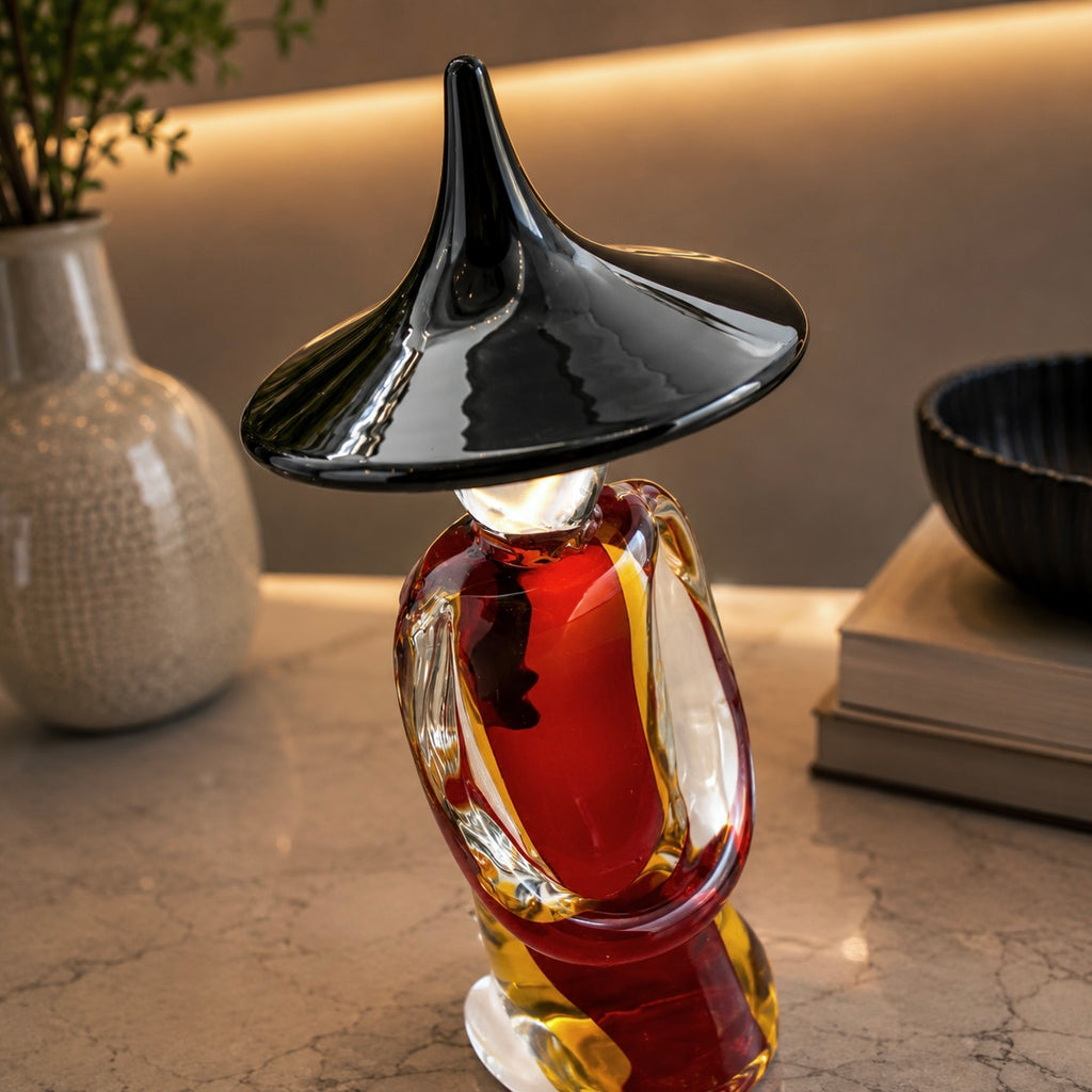 Decorative bottle with black cap and red body on a marble surface