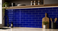 Kitchen with blue tiled wall and wooden cutting boards.