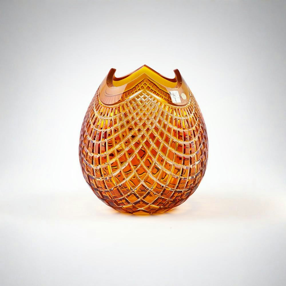 Decorative amber glass vase with textured pattern on a white background