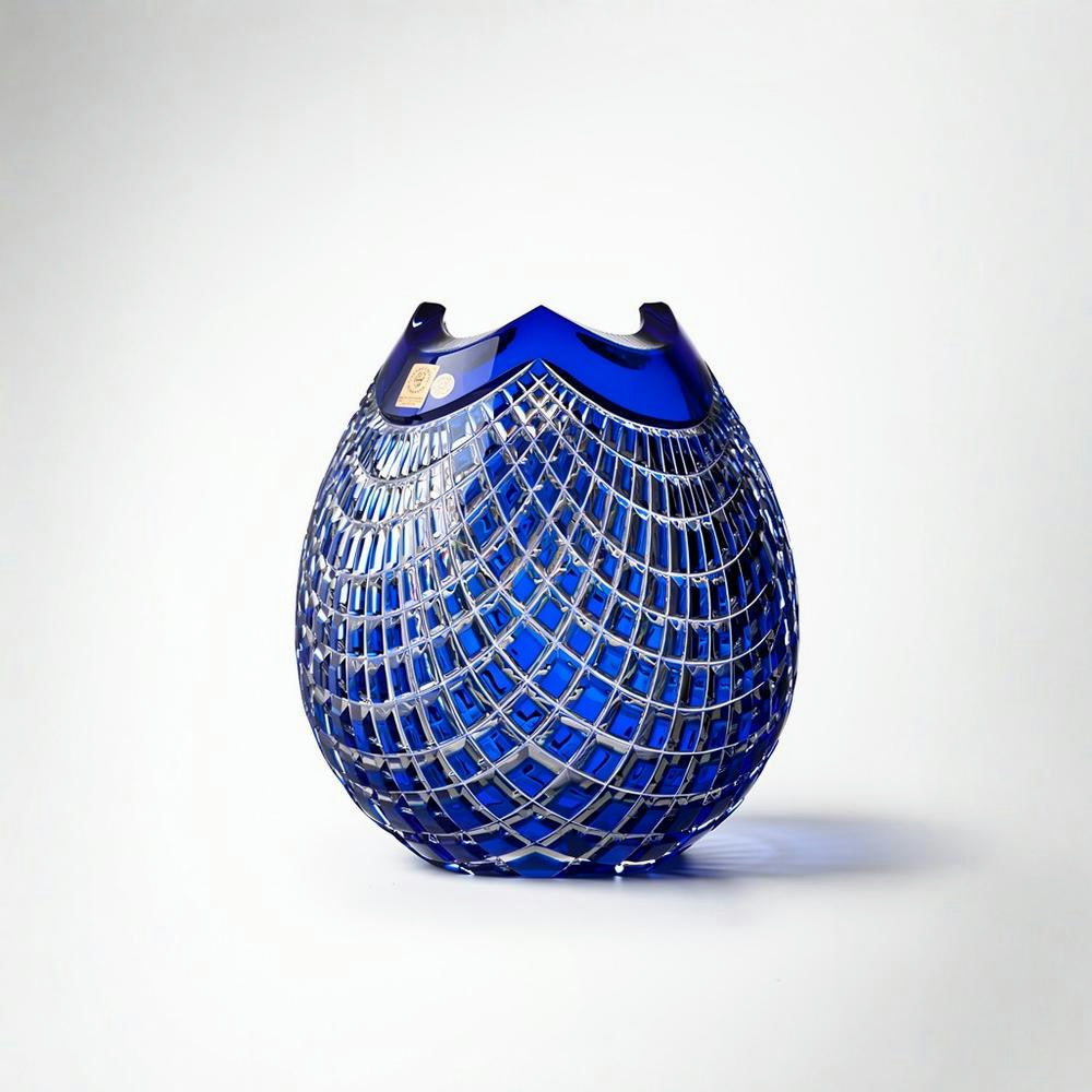 Blue glass vase with a textured, grid-like pattern on a white background