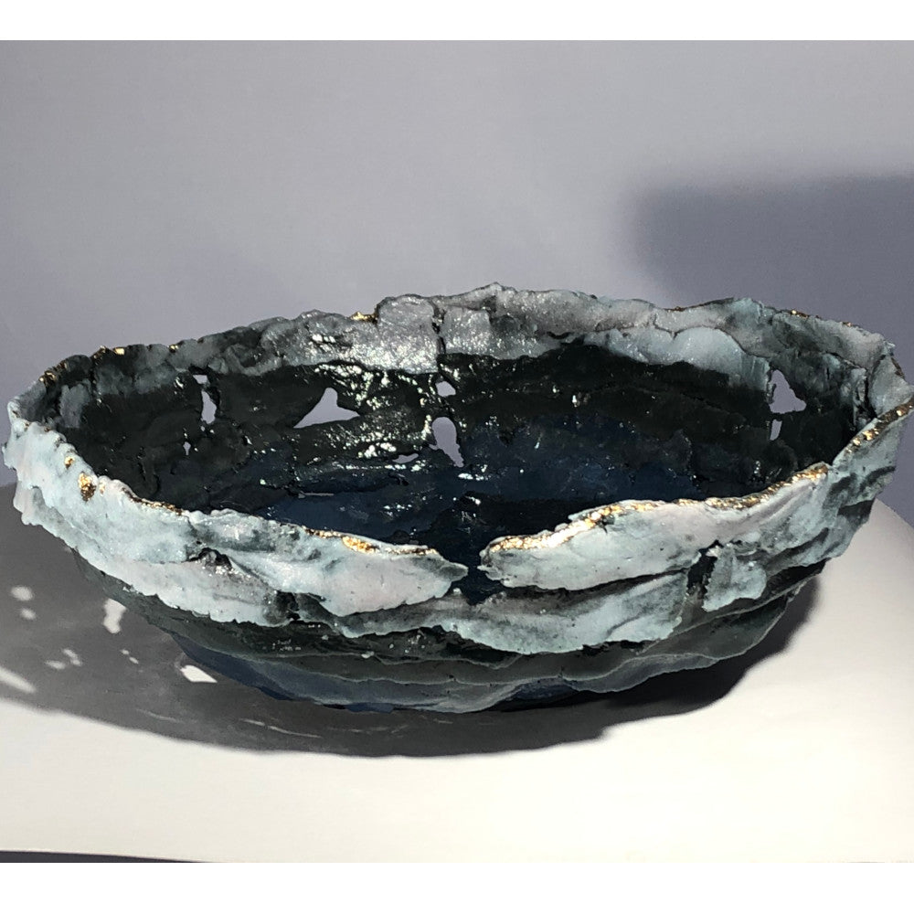 Decorative ceramic bowl with a textured surface on a gradient background