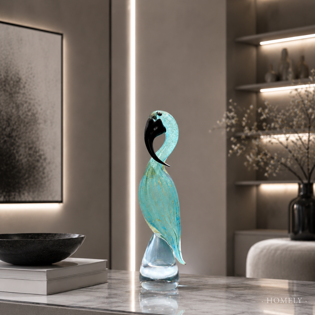 Decorative glass sculpture of a bird on a table in a modern interior setting.