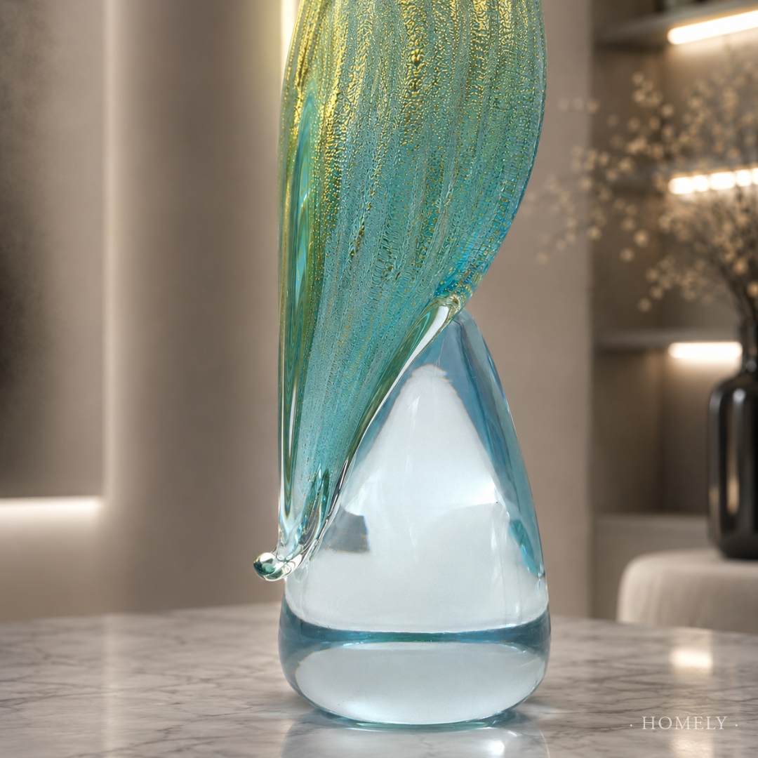 Glass sculpture with teal and white colors on a reflective surface
