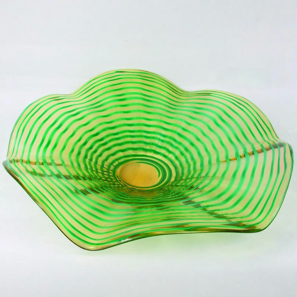 Green glass bowl with wavy design on a white background