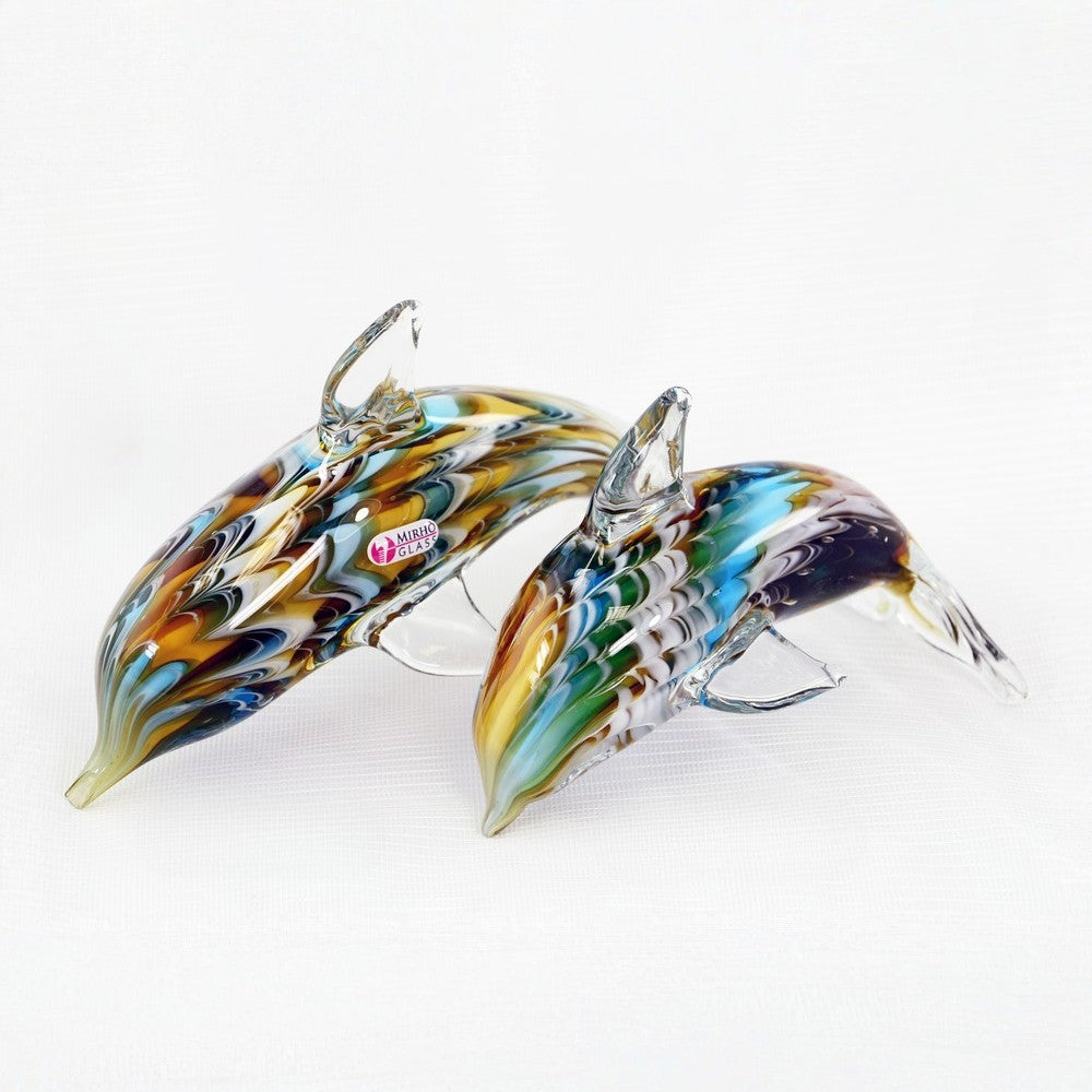 Two glass dolphins with multicolored swirl patterns on a white background