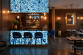 Modern bar interior with blue circular patterned wall and stools.