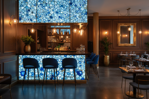 Modern bar interior with blue circular patterned wall and stools.
