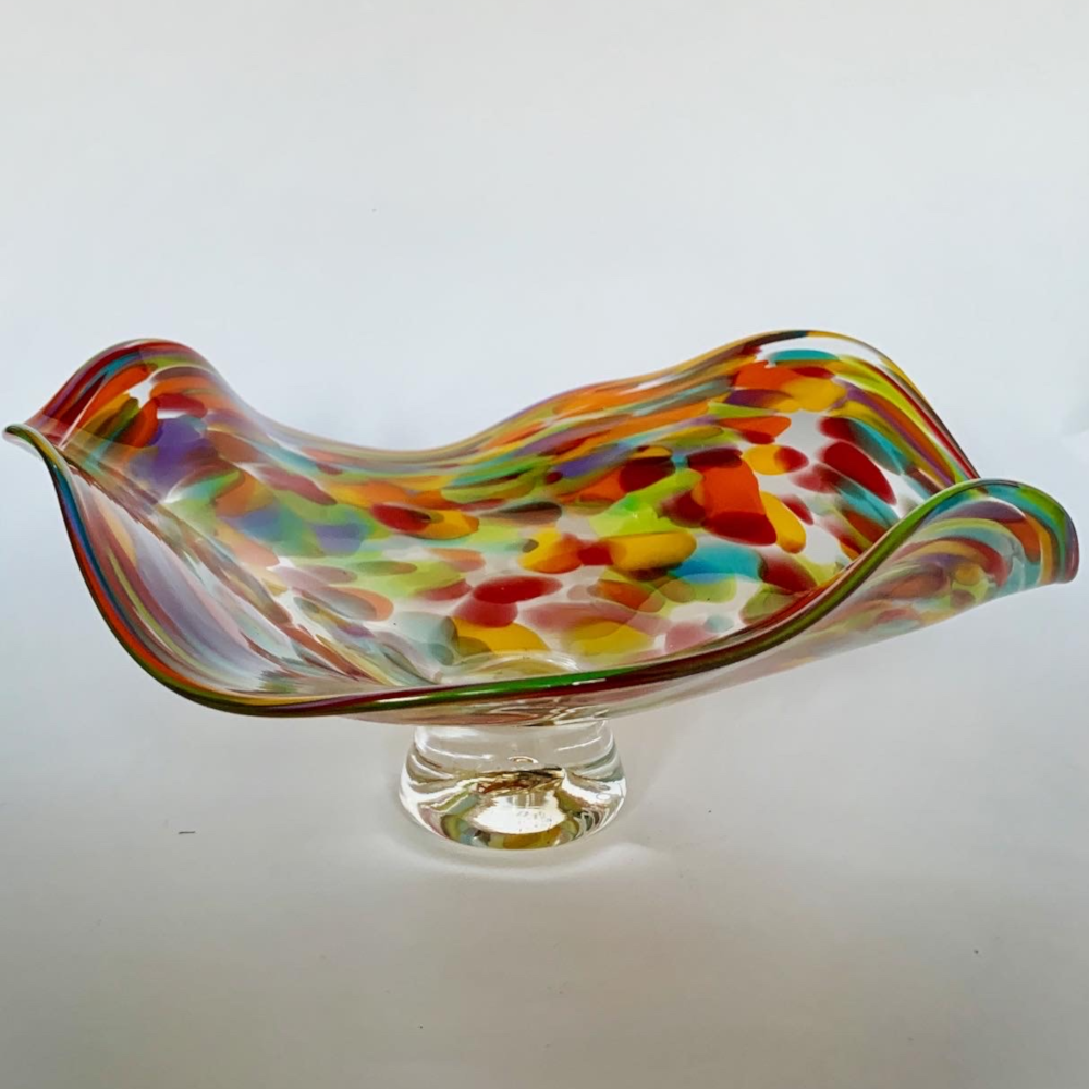 Colorful glass bowl with wavy design on a white background
