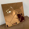 Gold geometric mirror on a white wall