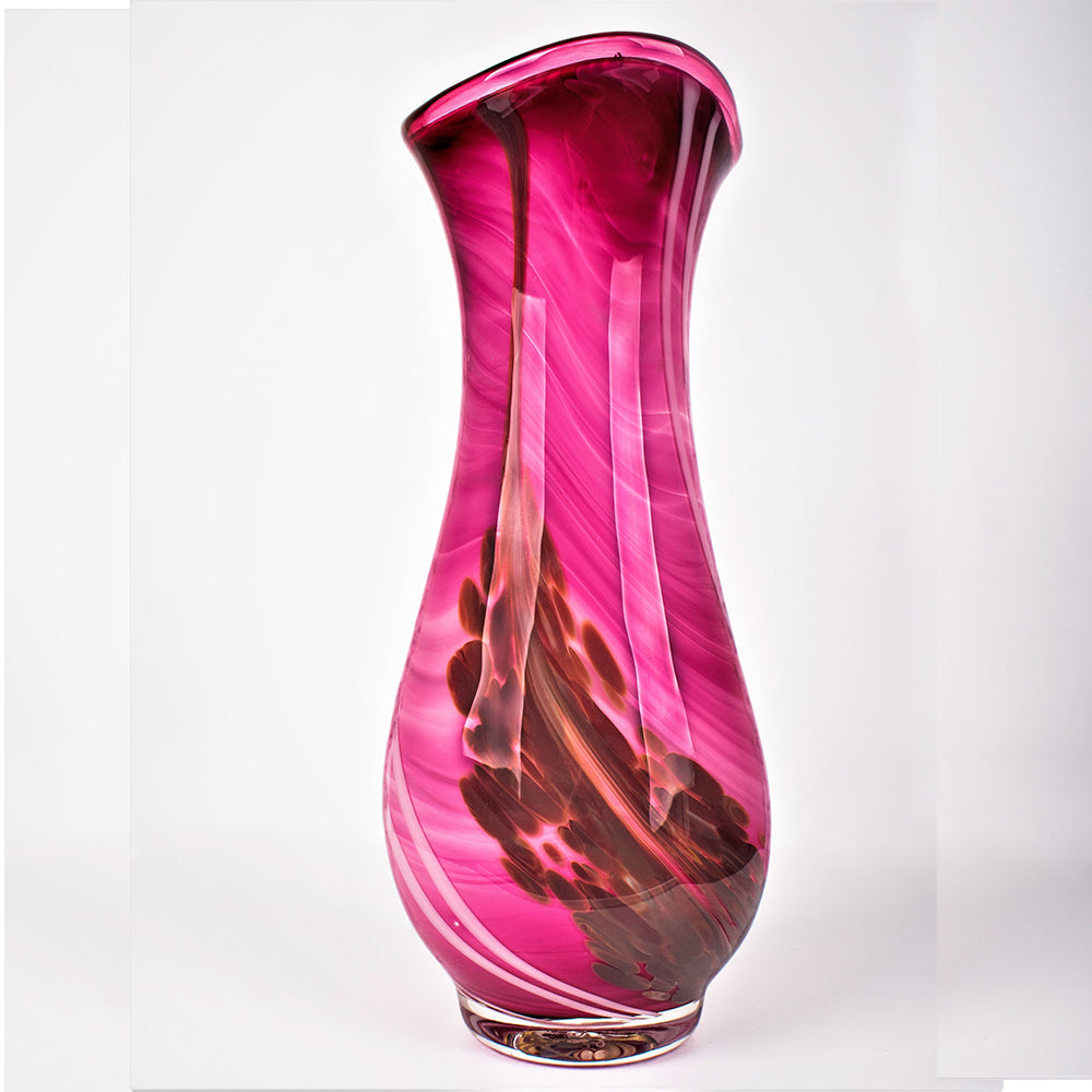 Pink glass vase with swirling patterns on a white background
